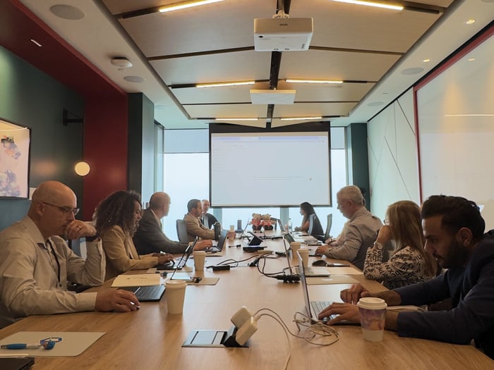 Empower 2025 Event with attendees participating in a conference session and technology discussion around a boardroom table