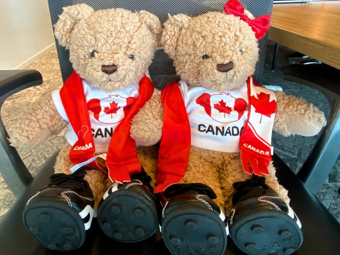 Hope & Hugo as branded teddy bear mascots displayed beside a coffee cup during a company event