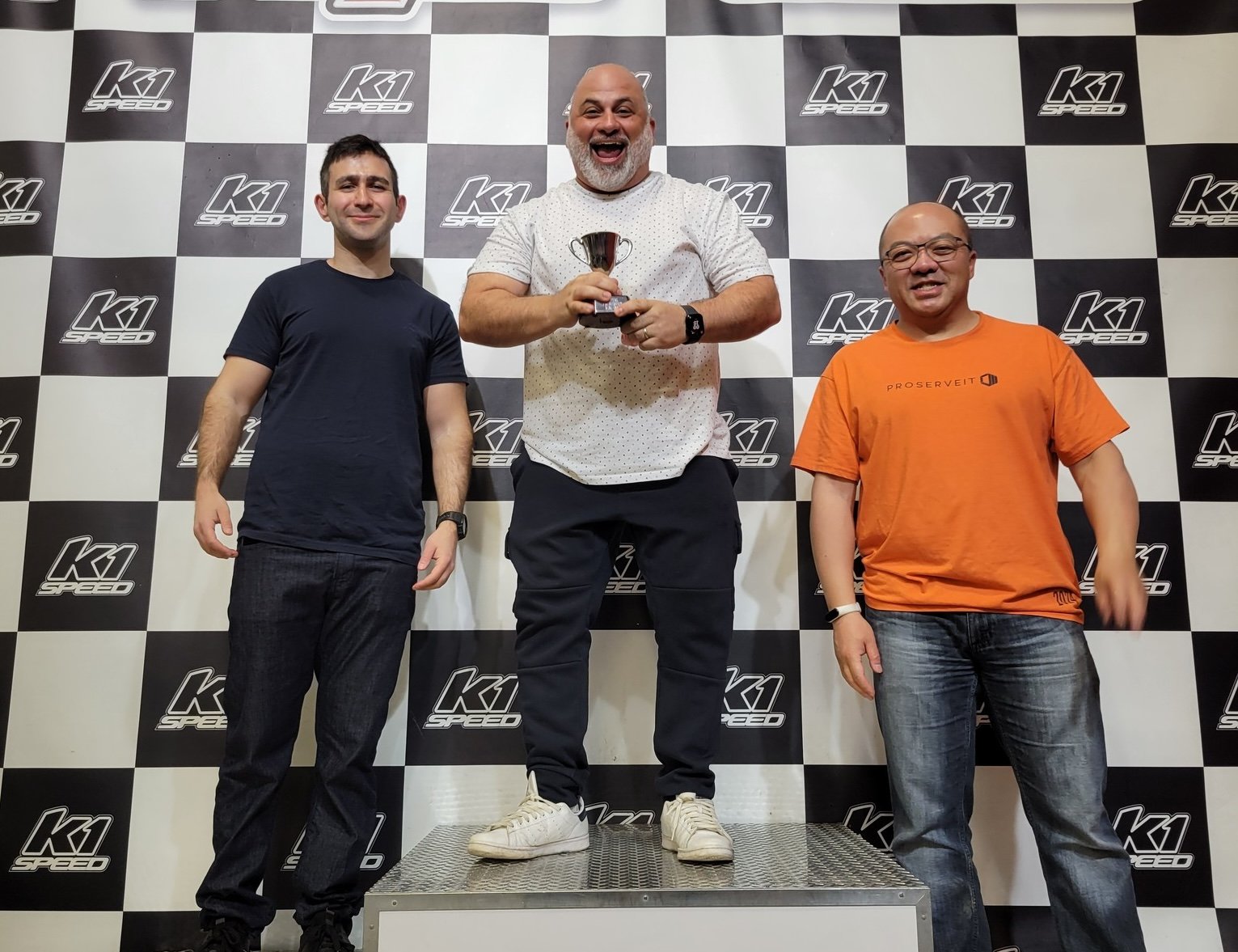 ProServeIT and Linezero team members standing at the podium after winning a go karting race at a social event