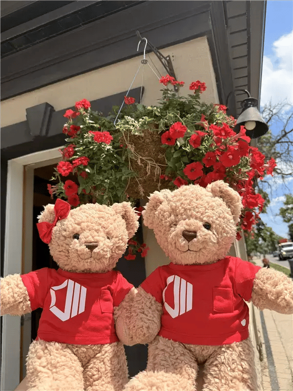 Hope and Hugo, ProServeIT's brand ambassadors, posing in matching red t-shirts with red flowers outside ProServeIT's office