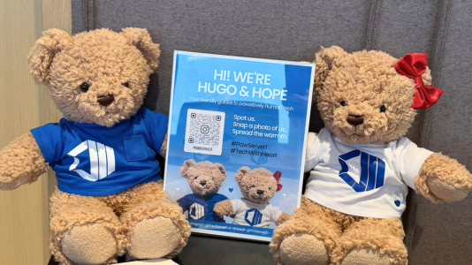 Hope and Hugo posing with a standee introducing themselves, at a ProServeIT event